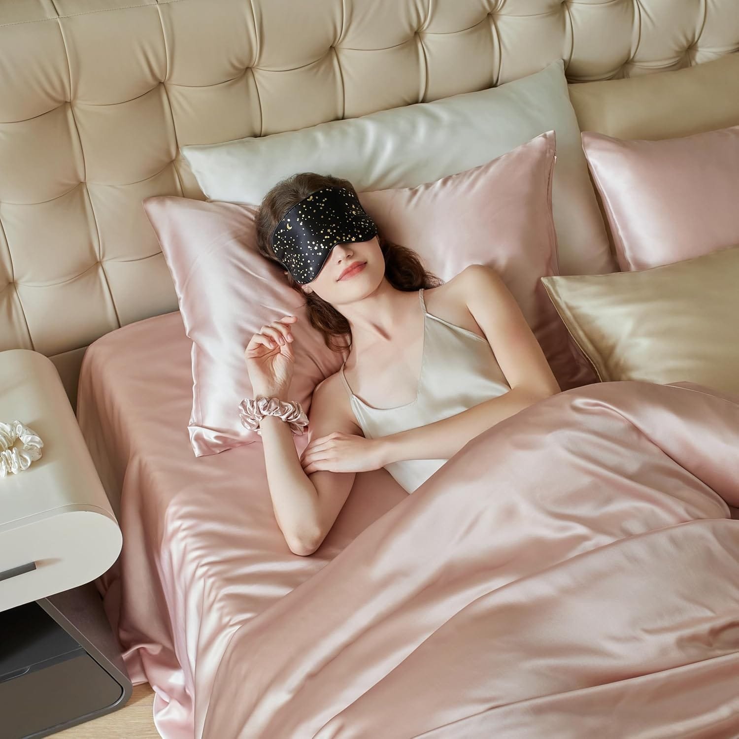 Lifestyle image of woman wearing silk sleep mask in bed