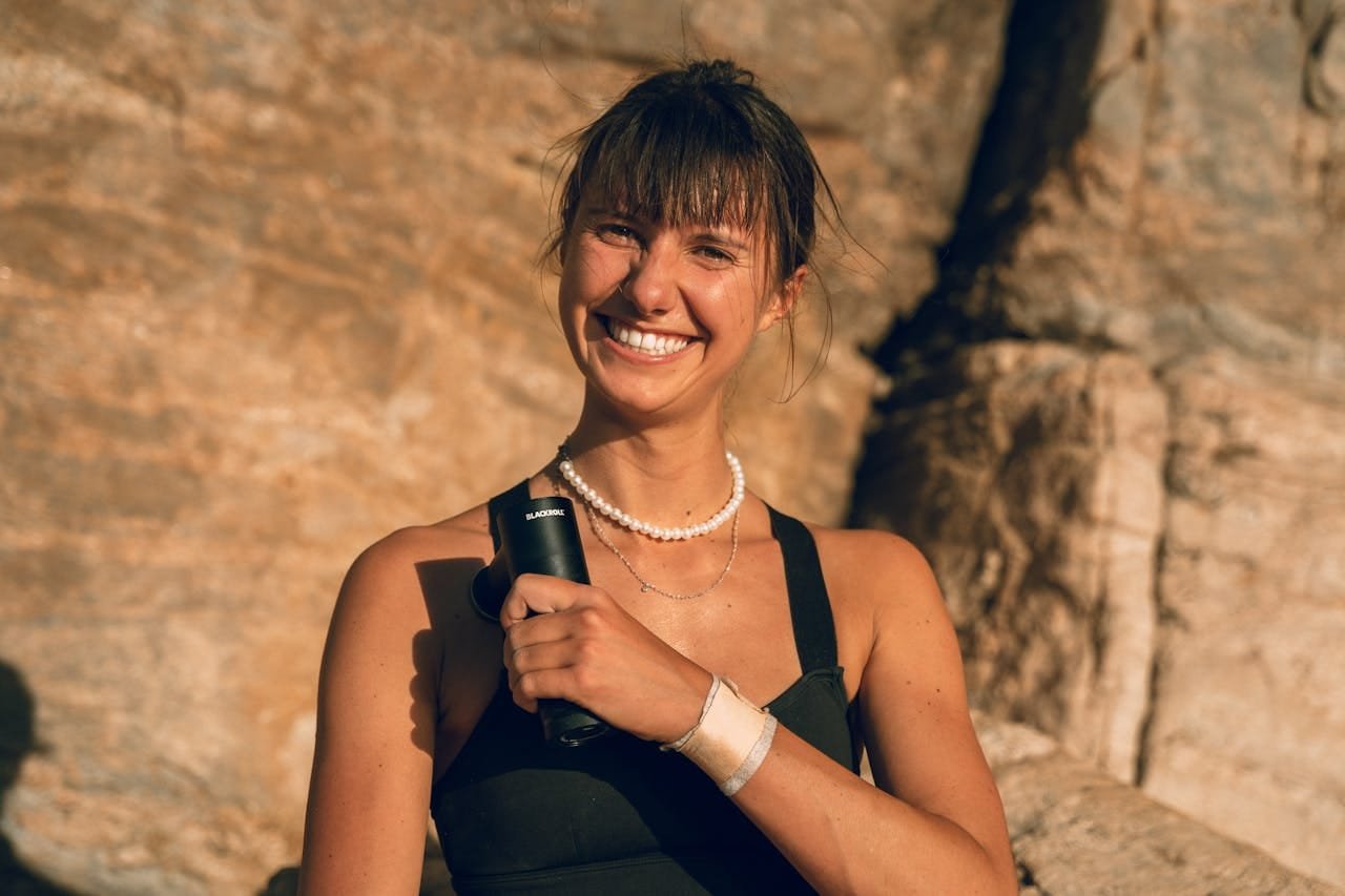 Woman using short handle massage gun for pain relief