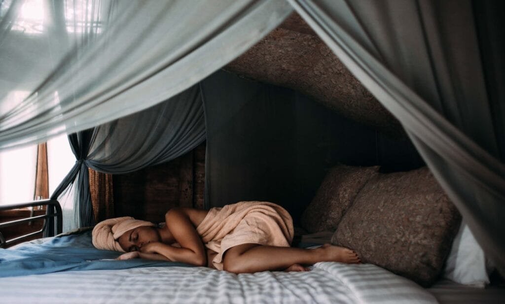 Woman sleeping peacefully with a towel wrapped around her head after a shower