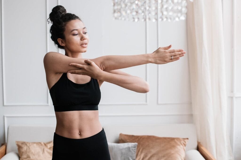 Woman stretching her shoulders at home to boost energy levels